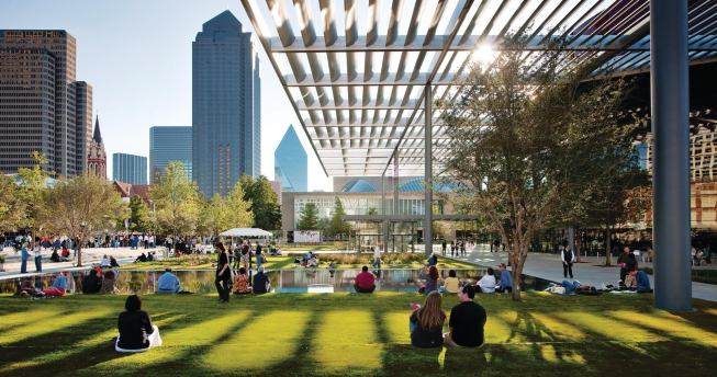 Visitors relax in Dallas’ new 10-acre Elaine D. and Charles A. Sammons Park, designed by French landscape architect Michel Desvigne. At right is the new opera house by Foster + Partners; its monumental canopy extends into, and provides shade for, the park.