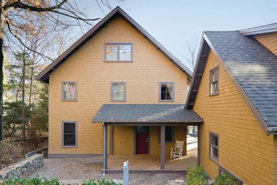 A wraparound porch connects the courtyard to the main entry, while the garage, at right, is detached but accessible by a covered walkway. Because the family’s minivan often runs for long periods while the wheelchair lift system is operating, the owners wanted to ensure that pollutants 

from the car would not enter the home. A bluestone ramp and sloped path, at left,

 lead to the lower backyard.