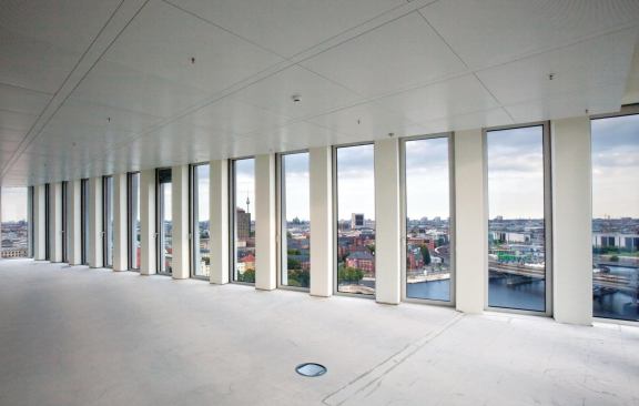 Other floors still sit empty, waiting for tenants, but a largely column-free interior allows for unobstructed views through the operable windows from Schüco International.
