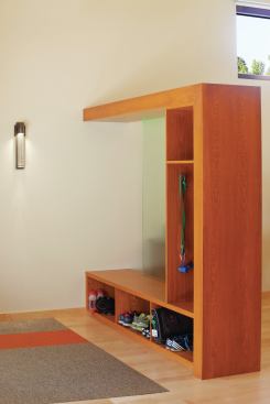 As spreading natural light was a main design goal, the fir storage cubby, also crafted by Teerlink Cabinets, separates the entryway from the dining area 

and is cut out to allow natural light to pass through.