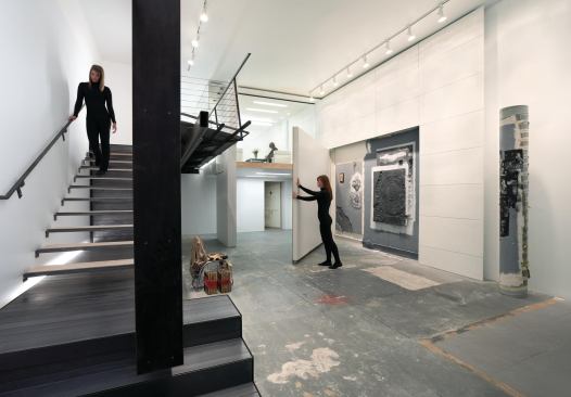 A folded wood wall helps define the gallery space.