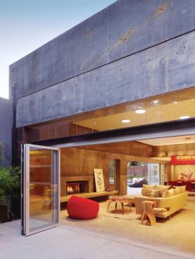 Well-planned landscaping softens the building's presence on a suburban cul-de-sac, while large openings and accordion doors help unite inside and outside.