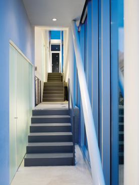 A corridor descends through the building from the entry to the main living space.