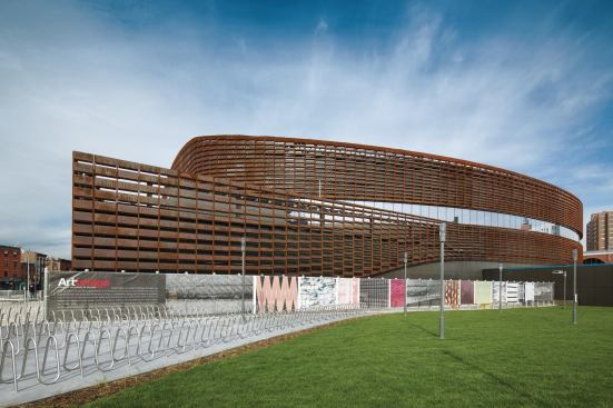 At the rear of the arena, the façade peels away to enclose the loading dock. 