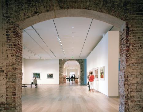 The museum’s new galleries combine pristine spaces for displaying art with remnants of the original structure, including historic masonry walls, hand-formed period Savannah Gray Brick, and original European oak flooring from the site’s 1853 rail depot.
