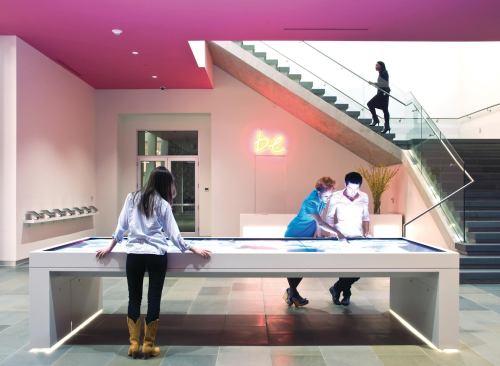 Behind the table, stairs lead to the second floor studio spaces, which accomodate both art and education programs.