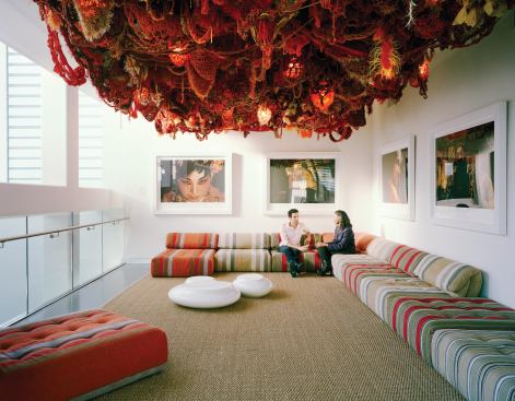 A second-floor studio accomodates gathering space under a ceiling-mounted installation.