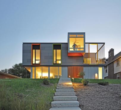 Seen from the rear, the colored frames of the home's apertures glow in the light.