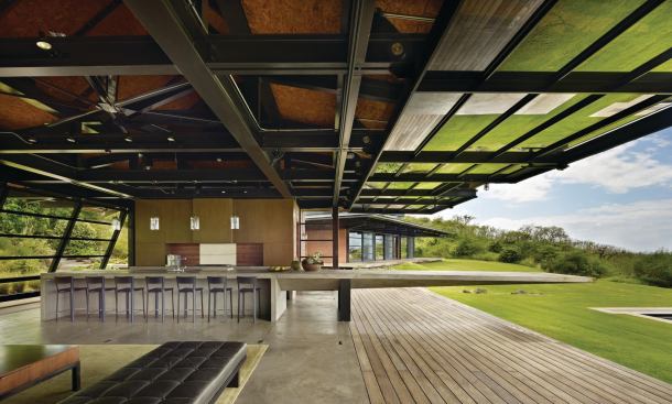 Hydraulic walls lift up to extend the living area (including a giant kitchen island) into the spectacular site.
