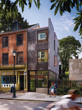The narrow addition bridges a historic 19th-century row house and a community garden located in the heart of Philadelphia's Washington Square West neighborhood.