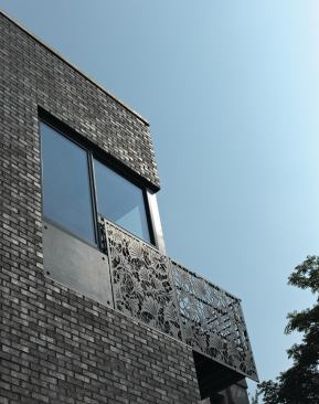 The buildings exterior is highlighted by glazed metallic brick and Cor-Ten steel panels with ginkgo leaf cutouts adapted from a traditional Japanese paper carving.