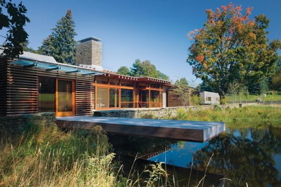 A deck extends the lattice-clad study over the pond.

