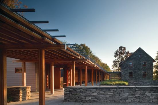 A glass passageway links the old stone cottage with a new milled timber house. Parallel linear corridorsone outside, one inside--lead from the parking court and garage to the house.

