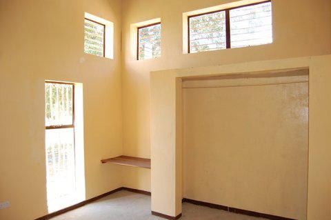A variety of windows, sized to address the angle of the sun, adequately daylight the rooms without contributing to heat gain. A band of clerestory windows filters light through a dried sugar-cane screen.