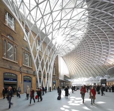 Underneath the 74-meter open span, passengers move through a plaza filled with shops, access the busy King’s Cross/St. Pancras Underground station, and purchase tickets for the trains that depart from the platforms beyond.