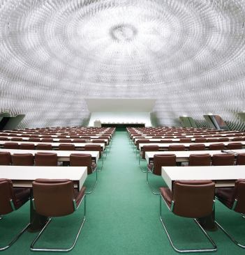 In 1966, Niemeyer began work on a number of projects in Paris, where he lived in exile. One of these was the headquarters for the French Communist Party. The project’s below-grade auditorium surfaces as a dome in front of the French Communist Party’s six-story tower.