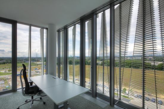The client brief mandated that a sunshading system be employed on the campus buildings, but that the view for employees not be obstructed. Even when closed, the small louvers that make up each fin allow for views while maximizing shading of the actual glazed façade.