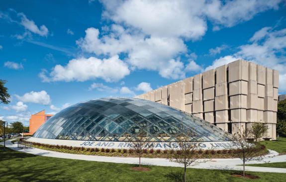 The elliptical glass dome of the Mansueto Library addition sits beside the existing Regenstein Library.