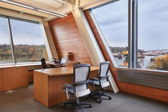 Private offices are few and far between in the largely open-plan building, but those along the western edge of the structure feature a slanted window wall.