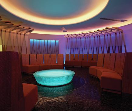 The focal point of the space is an illuminated glass sculpture surrounded by seating banquettes accented with wood trellises. 