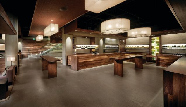 The two main horseshoe-shaped tasting bars were outfitted with custom wine display cases and signage that identifies each of the eight wineries that are in residence. Soffits help to define spaces in the open-plan space by defining tasting zones, circulation zones, and lounges. LIGHT FIXTURE FABRIC SHADE - Knoll Textiles - Imago Progeny drapery fabric in Blonde - knoll.com - PAINT - Kelly-Moore - Interior latex paint in black - kellymoore.com - WALL WASHER LIGHT FIXTURES - Danalite - Fluorescent T8 downlight wall washers - danalight.dk