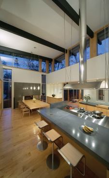 An oversized range hood dangles 15 feet down from the ceiling to just above the cooktop. “The island and dining table are low and horizontal,” says Petrarca, “so this gave us a way to fill the space and distinguish the zones.”