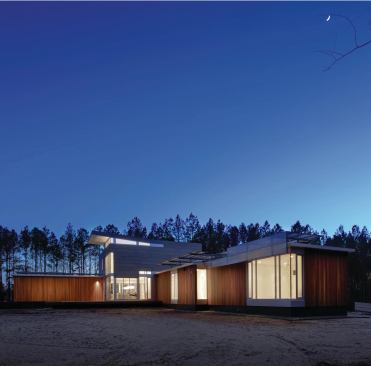 Long, narrow wings pinwheel out from the house's two-story core, maximizing the exposure of windows and rooftop solar panels.