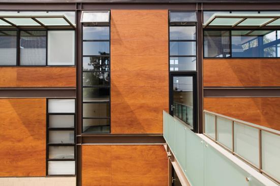 Wood-and-resin panels form an exterior rainscreen.