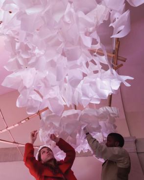 Workshop participants help to hang the paper lanterns.