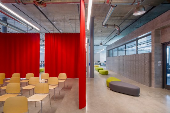 Red curtains that double as sound baffles separate presentation areas from the open studio.