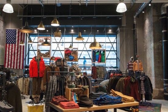 Uline Aena’s west elevation was originally solid masonry. Floor-to-ceiling windows now bring D.C.’s city pedestrian and public transit activity inside. The exposed footing of the original column (shown on the right) evinces the excavation of the space along with the layers of paint that covered the columns over time.