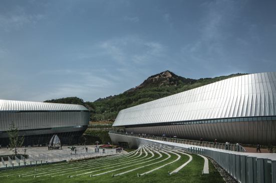 The four structures that make up the larger Theme Pavilion of the horticultural expo are low-slung shells connected by a series of landscaped plazas. 