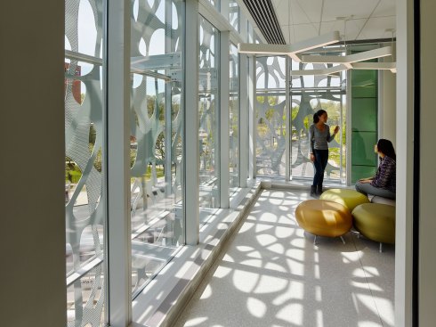 The scrim projects dynamic patterns into the collaborative work space at the end of the corridor.