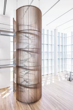 The lobby is a triple-height, light-filled volume. A spiral staircase, clad in wooden slats, provides circulation for those who do not want to wait for the elevators at the core of the building.