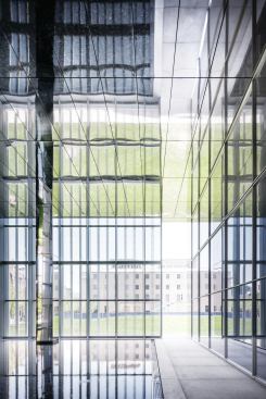 A reflecting pool in the northeast corner of the building is located behind the glass and aluminum skin; a break in the façade opens the space to parkland beyond.