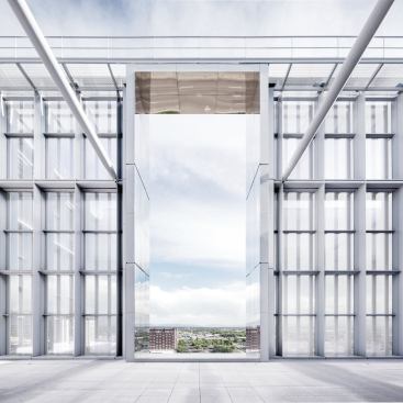 A roof terrace is sheltered behind the glass and aluminum curtainwall, but portals lined in polished stainless steel offer views of the distant mountains.