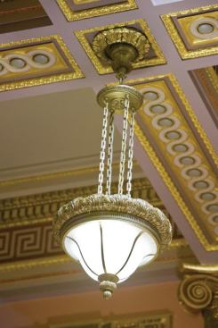 Surmounting the technical challenges, eight interchangeable, multi-lamp (compact fluorescent and ceramic discharge metal halide) flexible reflector assemblies were designed to fit the majority of historic luminaires. Each assembly provided a unique upward distribution, directed spill light into the luminaire’s decorative glass, permitted fine-tuning of room illuminances, all while articulating the volume’s architectural detail. By fully concealing all of the modern sources, the original character and design of each fixture was retained.