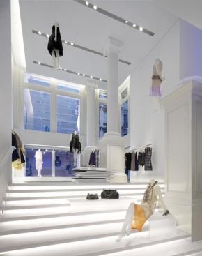 Custom extruded ceiling slots house mechanical systems and two multi-circuit tracks for controlling and hanging motorized theatrical equipment separately from AR111 spotlights. Fluorescent backlighting and translucent acrylic platforms allow the stair to double as display.