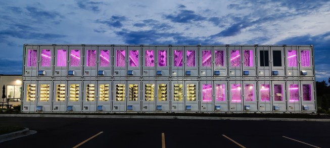 Square Roots v3, completed in 2022, is a vertical farming campus for farming technology company Square Roots. The latest complex, located in Kenosha, Wis., comprises a series of stacked shipping containers installed directly adjacent to a local distribution center for Gordon Food Service.