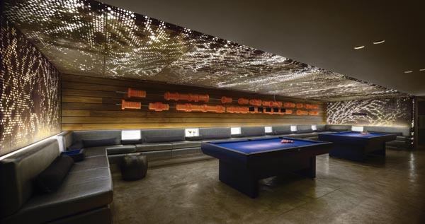 At the pool niche, flexible LED fixtures are mounted to coordinate with the perforated corten panels on the ceiling and walls.