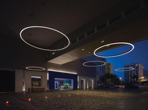 Illuminated rings add scale to the 40-foot-tall porte-cochère entry. Recessed in-grade luminaires serve as subtle lane dividers.
