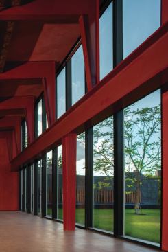 The multipurpose performance space in the western portion of the building seats up to 200. Its exposed steel beams are coated in a crimson red Sherwin Williams paint.