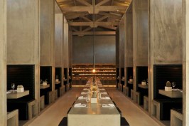 The dining room’s centerpiece— a large communal dining table— juxtaposes
 the space’s verticality, while large monolithic concrete booths provide
 a more intimate dining setting.