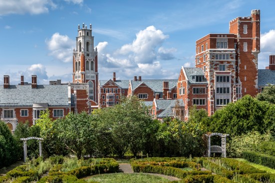 View of Benjamin Franklin College (at left) and Paul Murray College (at right), from the east. Prefabricated elements were used to ensure detailing and speed construction, including the chimneys, panels on Bass Tower (at middle), as well as window surrounds.